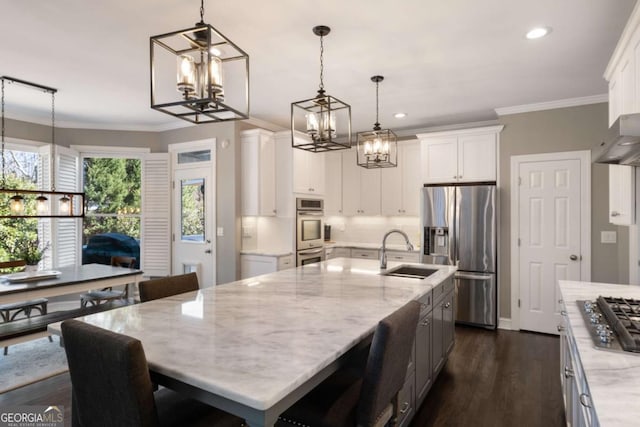 kitchen featuring a notable chandelier, stainless steel appliances, white cabinets, a sink, and light stone countertops