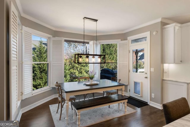 dining room with an inviting chandelier, baseboards, dark wood-style flooring, and crown molding