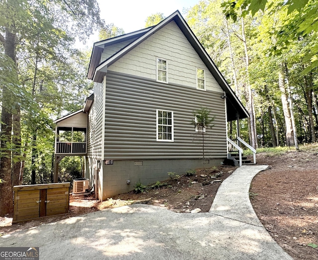 view of property exterior featuring faux log siding and crawl space