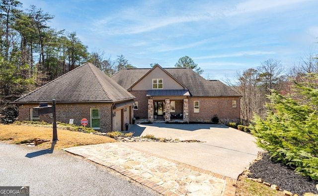 view of front of house featuring driveway, brick siding, an attached garage, and a shingled roof