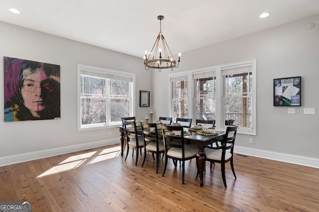 dining room with a notable chandelier, baseboards, hardwood / wood-style floors, and recessed lighting