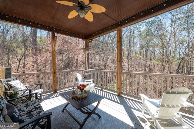 unfurnished sunroom with wood ceiling, ceiling fan, and a wealth of natural light