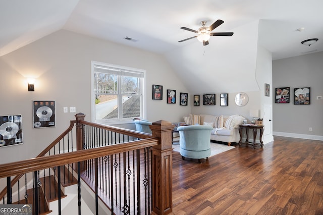 living room with dark wood-style floors, lofted ceiling, visible vents, and baseboards