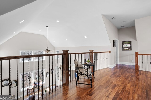 hall with baseboards, visible vents, wood finished floors, an upstairs landing, and high vaulted ceiling