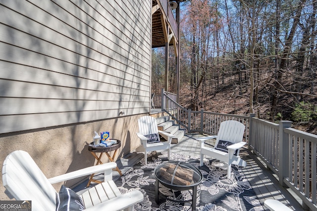 wooden terrace featuring an outdoor fire pit