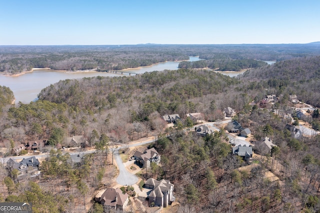 drone / aerial view with a water view and a forest view