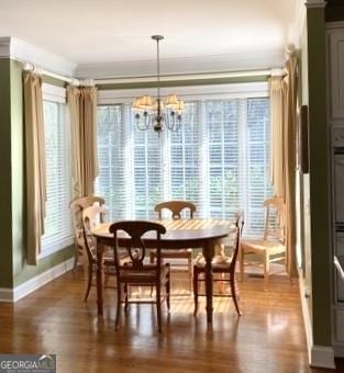 dining space featuring dark wood-style floors, baseboards, and an inviting chandelier