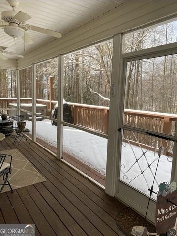 unfurnished sunroom featuring wood ceiling and ceiling fan