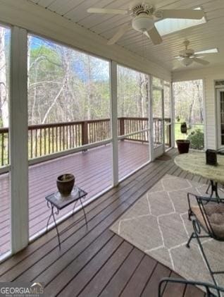 sunroom featuring a ceiling fan and wooden ceiling