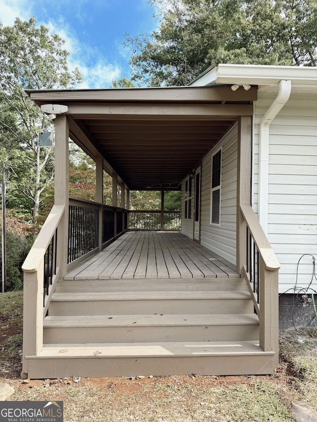 wooden deck featuring an attached carport