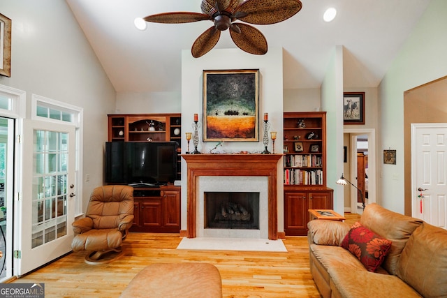 living room featuring a fireplace with flush hearth, ceiling fan, wood finished floors, high vaulted ceiling, and recessed lighting