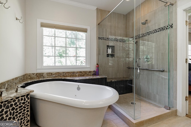 full bathroom featuring a freestanding tub, a shower stall, and crown molding