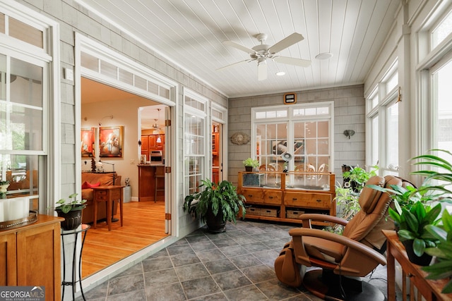 sunroom / solarium featuring wooden ceiling and a ceiling fan