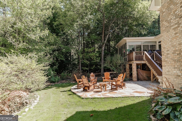 view of yard featuring a sunroom, stairs, and a patio