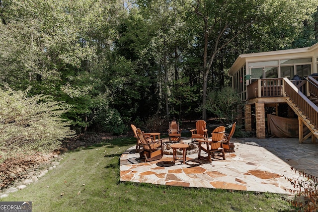 view of patio / terrace featuring stairs and a sunroom