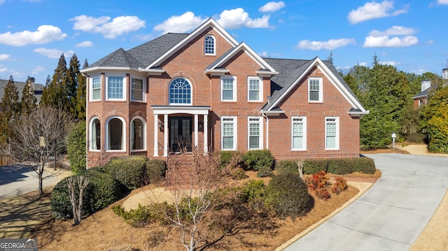 view of front of home with driveway and brick siding