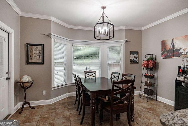 dining space with baseboards, ornamental molding, stone finish floor, and a notable chandelier