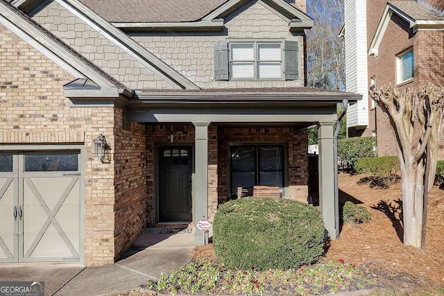 entrance to property with a garage and brick siding