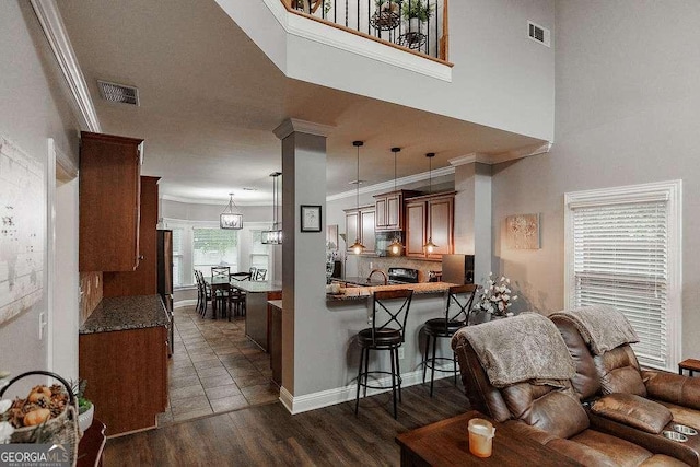 kitchen with tasteful backsplash, visible vents, a breakfast bar area, and ornamental molding