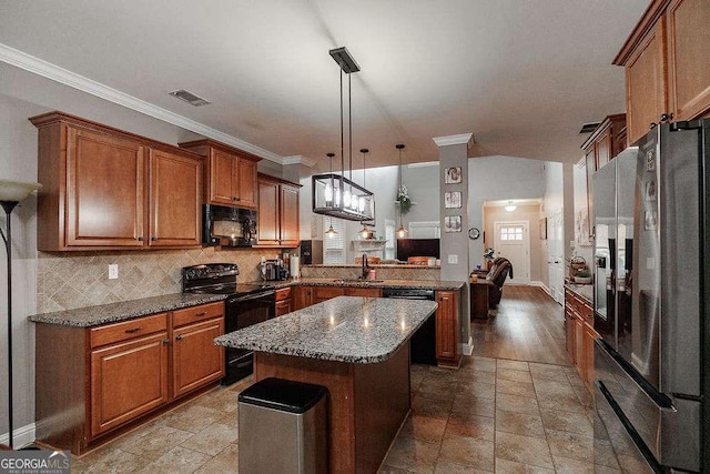 kitchen featuring stone tile floors, visible vents, brown cabinetry, a sink, and black appliances