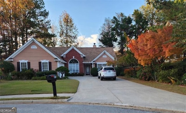 view of front of home with a front yard and concrete driveway