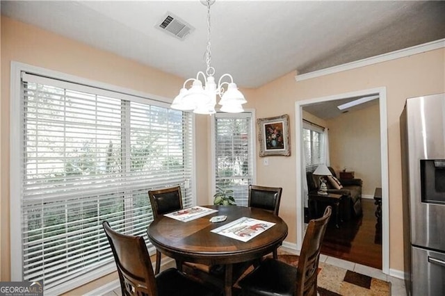 dining room featuring light tile patterned flooring, a notable chandelier, visible vents, baseboards, and vaulted ceiling