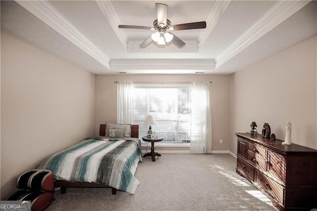 carpeted bedroom featuring ornamental molding, a tray ceiling, baseboards, and a ceiling fan