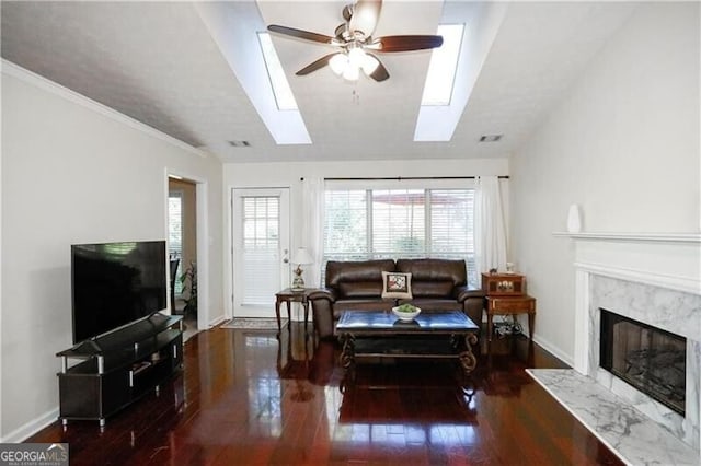 living room with a ceiling fan, a premium fireplace, baseboards, and wood finished floors