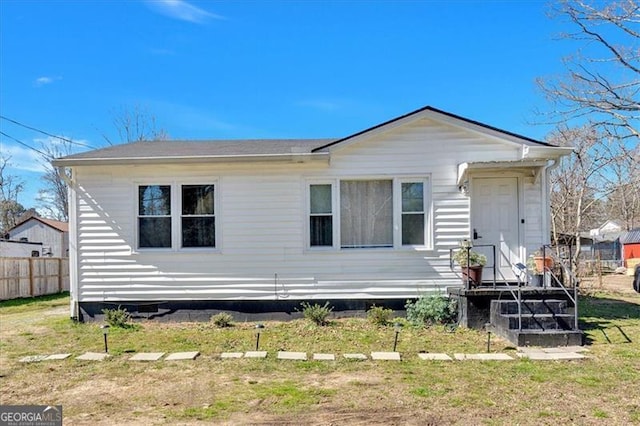 view of front of house with fence and a front lawn