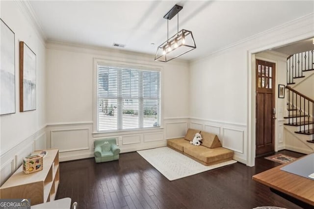 interior space with hardwood / wood-style flooring, a wainscoted wall, visible vents, stairs, and ornamental molding