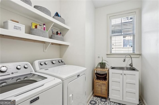 laundry room with laundry area, washing machine and clothes dryer, a sink, and baseboards