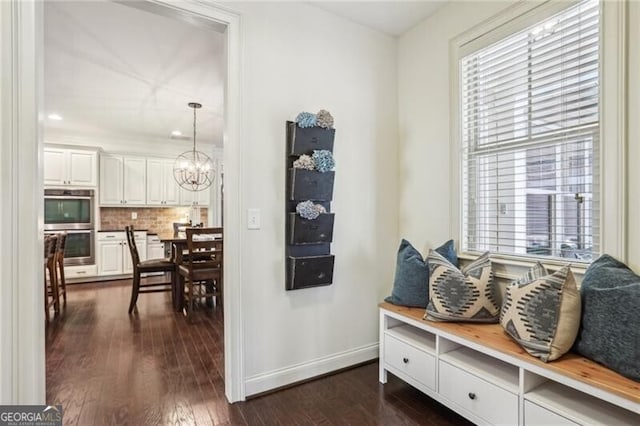 mudroom with a notable chandelier, baseboards, and dark wood-style flooring