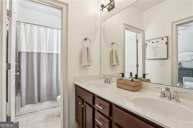 full bathroom with double vanity, a sink, toilet, and tile patterned floors