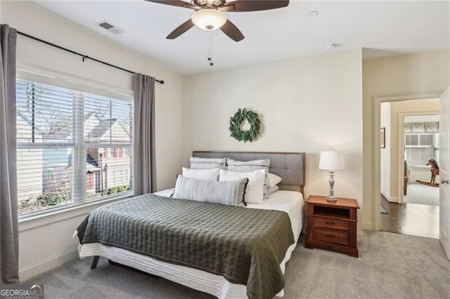 bedroom featuring carpet floors, baseboards, visible vents, and ceiling fan