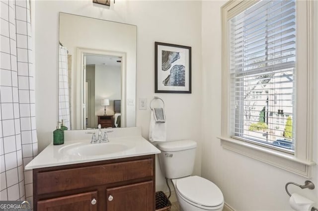 bathroom featuring toilet, a shower with curtain, and vanity