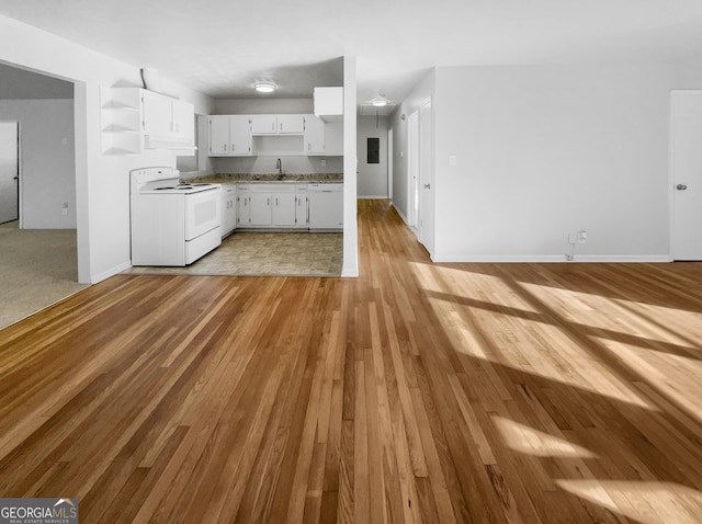 kitchen with white appliances, light wood finished floors, white cabinets, open shelves, and a sink