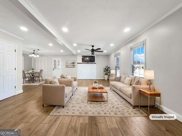 living area featuring crown molding, baseboards, wood finished floors, and recessed lighting