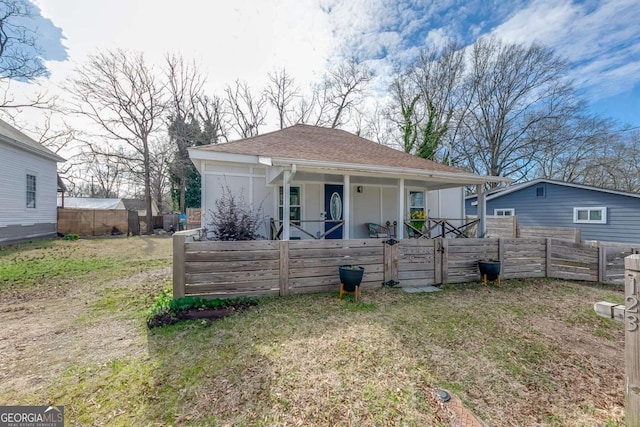 bungalow-style house with roof with shingles and fence