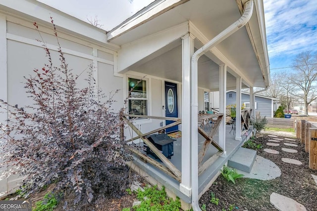 exterior space featuring a porch and fence