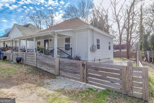 view of home's exterior featuring a porch, fence, and a shingled roof