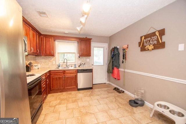 kitchen featuring tasteful backsplash, visible vents, stainless steel appliances, light countertops, and a sink