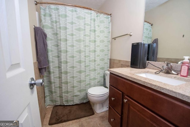 bathroom with curtained shower, vanity, and toilet