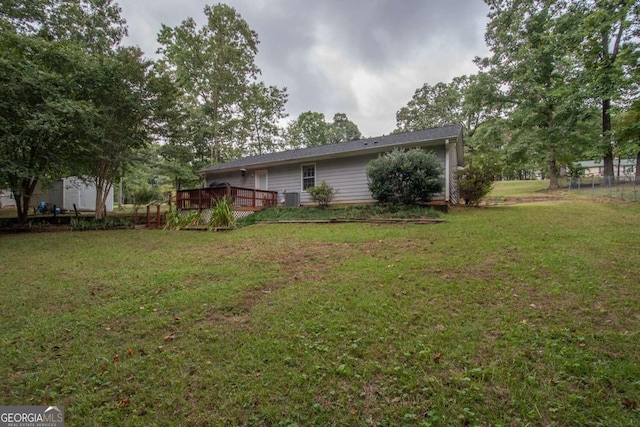 view of yard featuring a wooden deck and central air condition unit