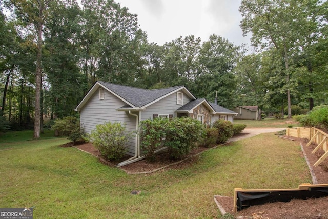 view of property exterior with roof with shingles and a lawn