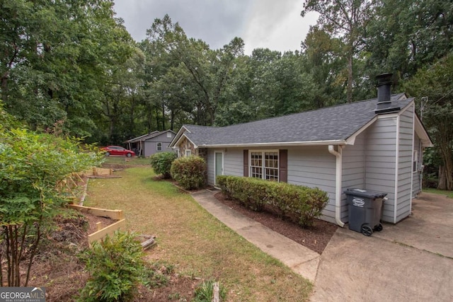 ranch-style home featuring a front lawn, roof with shingles, and a chimney