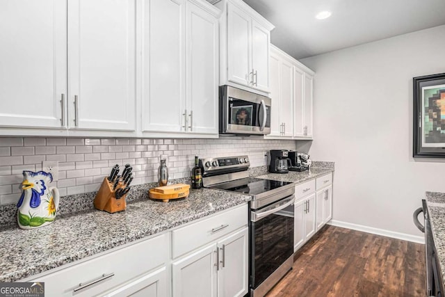 kitchen with light stone counters, dark wood-style flooring, decorative backsplash, appliances with stainless steel finishes, and white cabinets