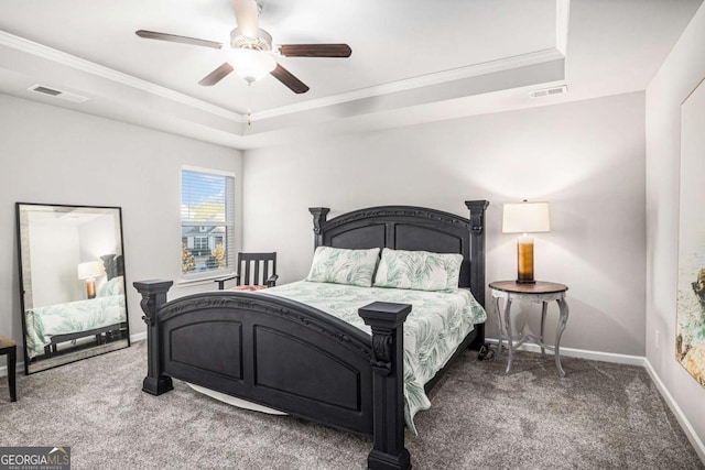 carpeted bedroom featuring baseboards, visible vents, a raised ceiling, and a ceiling fan