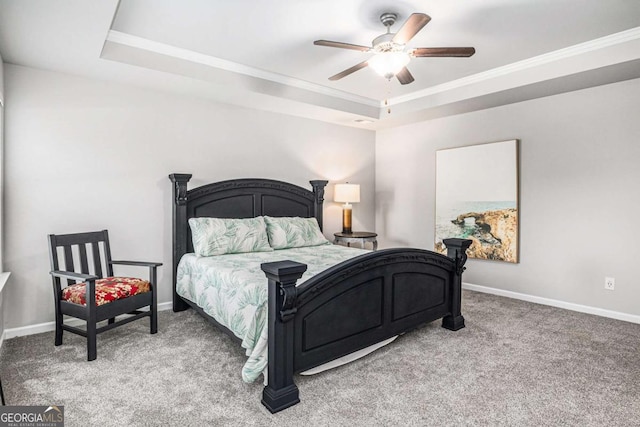 carpeted bedroom with baseboards, a tray ceiling, and crown molding