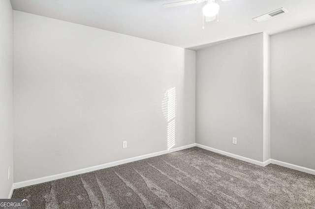 carpeted empty room with baseboards, visible vents, and ceiling fan