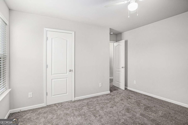 unfurnished bedroom with a ceiling fan, carpet flooring, and baseboards